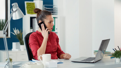 Obraz premium Executive manager talking on phone call with colleagues to plan startup project with charts and graphs. Sales consultant working on business development with smartphone conversation.