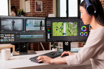 Video editor editing audio film montage with post production software on computer. Videographer...
