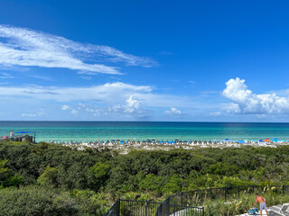 An aerial view of the Beach with Blue Umbrella and Lounge Chairs lined up at the Watercolor Community Club in Watercolor, Florida.