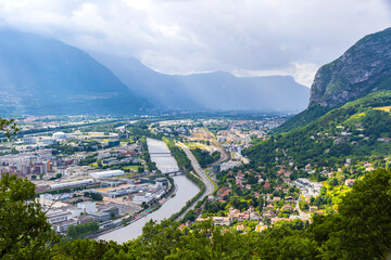 Grenoble city and Isere river, France. Picturesque aerial view from Bastille in summer cloudy day