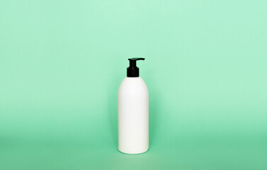 Liquid container for gel, lotion, cream, shampoo, bath foam. Cosmetic plastic bottle with dispenser pump on green background. Cosmetic packaging mockup with copy space.