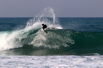 Surfing on high waves in the Mediterranean.