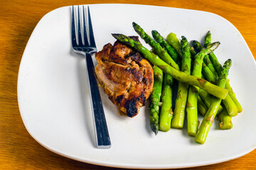baked chicken thigh  served with  sauteed asparagus,