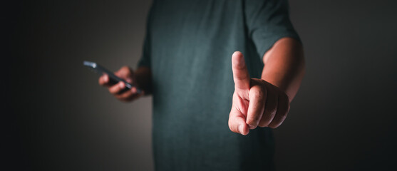 Businessman using mobile phone pointing up and showing with thumb up for touch