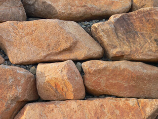 Close up abstract of orange stone boulders in a wall