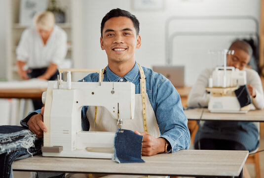 Young adult fashion designer in sewing workshop. Professional man in clothing and material design at work with diverse group of employees. Creative, innovative tailor working in a design studio