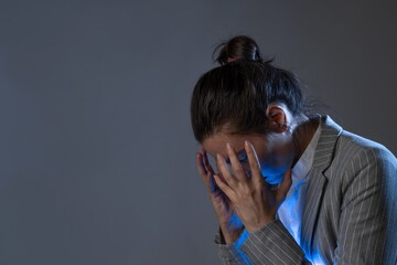 Stress at work and professional burnout. young woman in a business suit standing clutching head,...