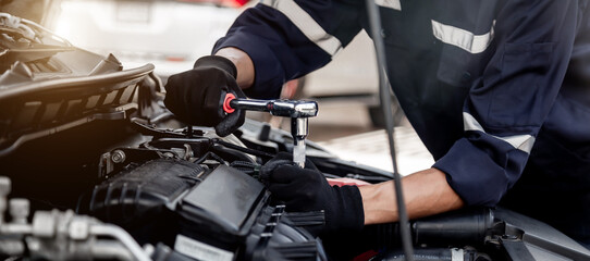 Car care maintenance and servicing, Close-up hand technician auto mechanic using the wrench to...