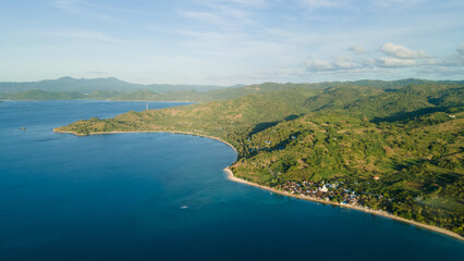 drone view of tropical island, hills and forest by the beach in the evening