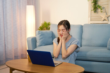 Fototapeta premium 夜にリビングでパソコンを見て困る女性