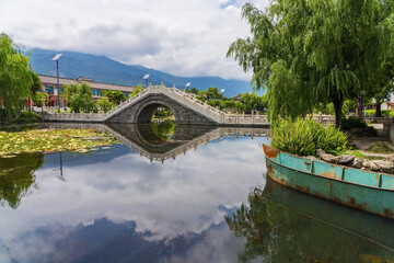 Ancient stone arch bridge and lotus pond in Dali Park, Yunnan Province, China