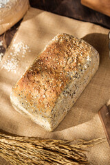 whole wheat baking bread with grains for healthy eating on wood table in kitchen