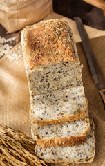 whole wheat baking bread with grains for healthy eating on wood table in kitchen