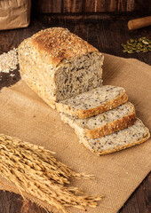 whole wheat baking bread with grains for healthy eating on wood table in kitchen