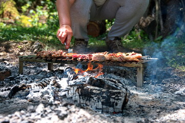 Grilling various meat and vegetables on flame