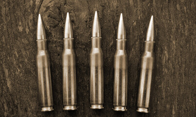 Rifle cartridges on a camouflage background. Top view. Sepia