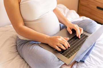 Naklejka premium Pregnancy computer app. Pregnant woman holding digital laptop. Mobile pregnancy online maternity notebook application. Concept maternity, pregnancy, childbirth.