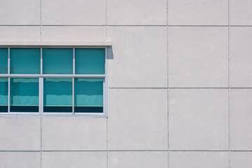 Minimal geometric architecture background of glass windows on large square concrete tiles wall of office building
