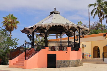 A gazebo with stairs, old style, and orange in color.