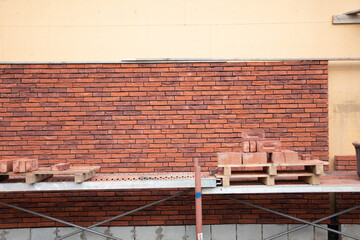 a new House is being built, the beginning of brickwork with red bricks, building