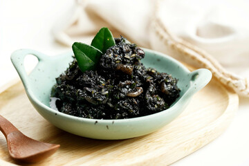 Stir Fried Squid and Chili in Black Squid Ink Sauce Served in Ceramic Plate. Known as Tumis Cumi Hitam Pedas In Indonesia.