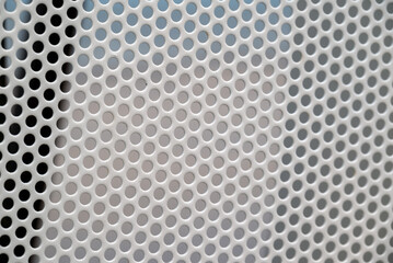 Metalic gray painted mesh with round holes.