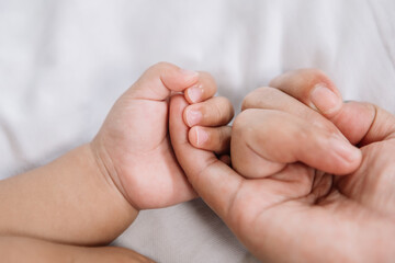 Obraz na płótnie Canvas Close up baby hand on mother's hands