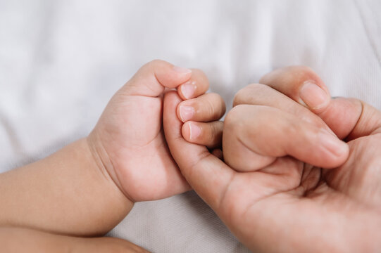 Close up baby hand on mother's hands