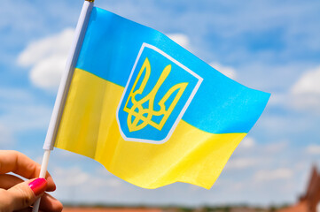 the national yellow and blue flag of Ukraine with trident on blue sky background
