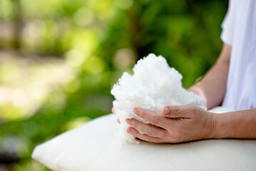 Man's hand holding White Polyester fiber with white pillow