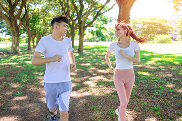 Happy young couple jogging in the  park on sunny day