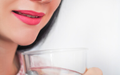 Close up of young woman drinking glass of pure still water