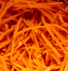Orange peeled carrots in a salad as a background.