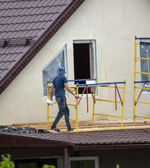 Fototapeta premium Workers are plastering the walls of the house.