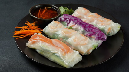 Vietnamese Spring Rolls Goi Cuon or Nem Cuon,  filled with prawns, herbs, rice vermicelli and vegetables. Served with hoisin and peanut sauce dip.