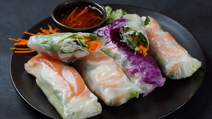 Vietnamese Spring Rolls Goi Cuon or Nem Cuon,  filled with prawns, herbs, rice vermicelli and vegetables. Served with hoisin and peanut sauce dip.