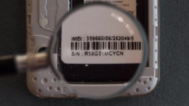 checking imei serial number code on smart phone mobile using magnifying glass or magnifier lens,smartphone security