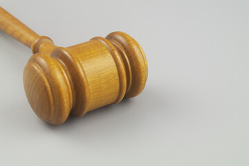 Wooden judge gavel on gray background close up. Laws, justice, court and legal system concept.