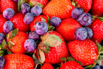 Pile of juicy ripe strawberries and blueberries berries summer healthy vegetarian and vegan food. - 520151151