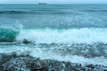 Nature background with sea waves hitting the sea shore. Scenic view of sea against cloudy sky