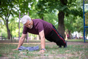 Senior sportsman doing push-ups in the park
