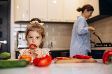 Mother with daughter preparing salad at the kitchen