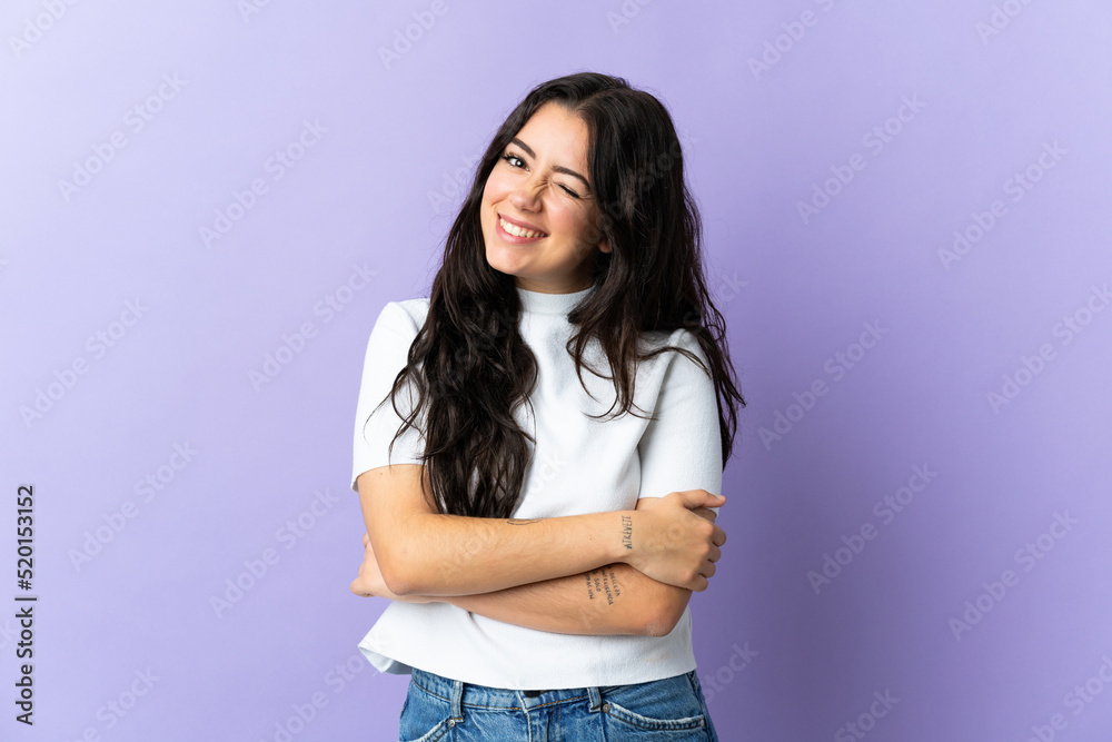 Wall mural Young caucasian woman isolated on purple background laughing