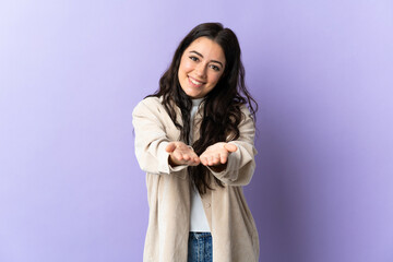 Young caucasian woman isolated on purple background holding copyspace imaginary on the palm to...