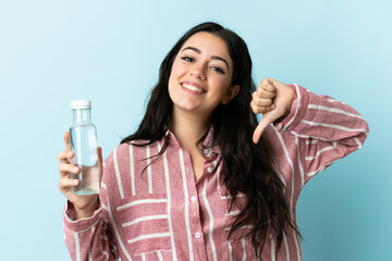 Young woman with a water isolated on blue background proud and self-satisfied