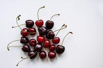 Obraz na płótnie Canvas Cherries are placed in a pile on a white background flatlay