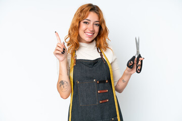 Young caucasian seamstress woman isolated on white background showing and lifting a finger in sign of the best