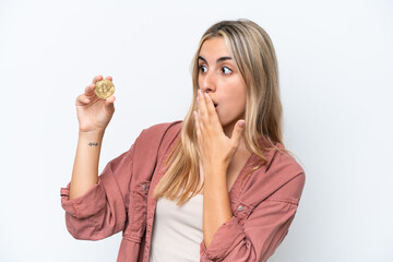 Young caucasian woman holding a Bitcoin isolated on white background with surprise and shocked facial expression