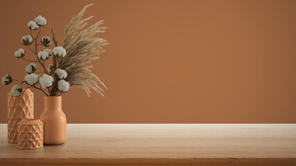 Interior design concept, wooden table, desk or shelf close up. Ceramic vases with dry plants, and cotton flowers. Orange background with copy space, template mock up idea
