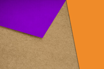 Plain and Textured pastel brown purple orange yellow papers randomly laying to form M like pattern and triangle for creative cover design idea